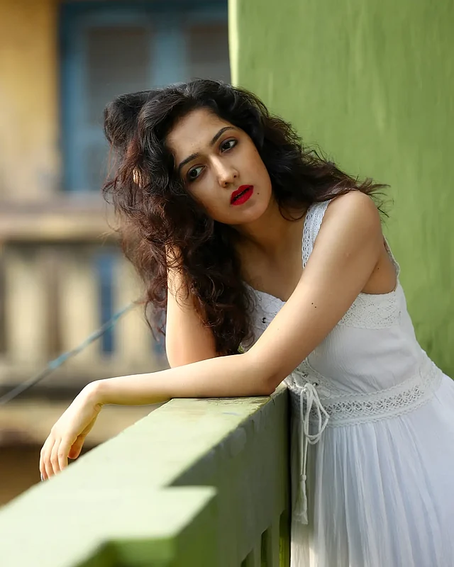 লেস ডিটেইলিং সাদা স্লিভলেস মিডি ড্রেসে অমৃতা যেন শুভ্রতার আবেদন ছড়িয়ে দিয়েছেন। সঙ্গে আরও আকর্ষণ যোগ করেছে তাঁর রেড লিপ লুক আর এক ঢাল কোঁকড়া চুল 