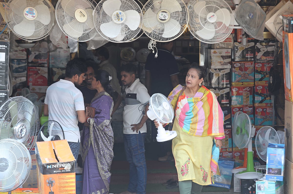 চট্টগ্রাম নগরের রাইফেল ক্লাব মার্কেটে থরে থরে সাজানো রিচার্জেবল বৈদ্যুতিক পাখা, একটি কিনে ফিরছেন এক নারী। 