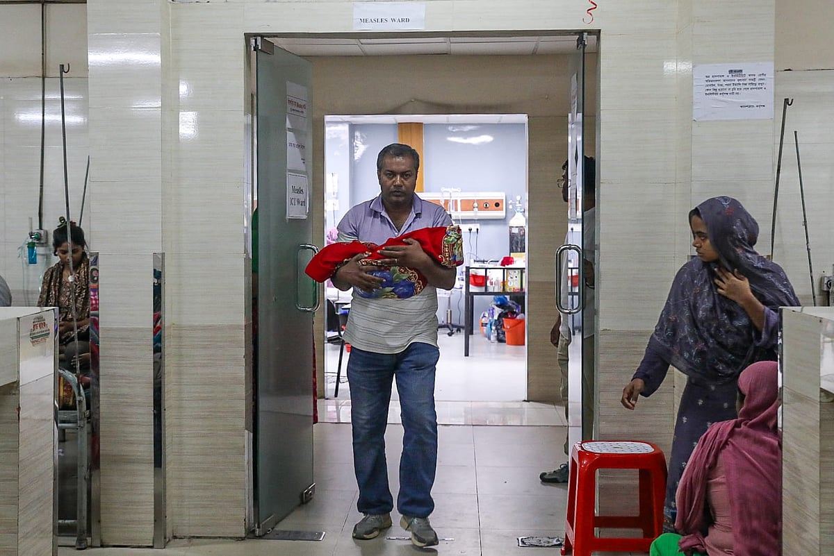 কাপড়ে মোড়ানো মৃত ইরফানকে কোলে নিয়ে হাসপাতাল থেকে বেরিয়ে আসছেন এক স্বজন 