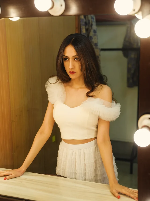 সাদা অফ-শোল্ডার রাফলড ক্রপ টপ ও স্কার্টে নজর কাড়ছেন এই সুন্দরী।