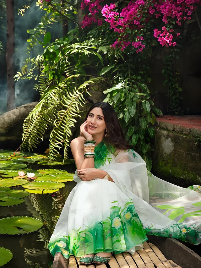 বাগানবিলাসের ব্যাকগ্রাউন্ড আর পদ্মপুকুরের শান্ত জলের মাঝে ডিঙি নৌকায় সাফাকে দেখা যাচ্ছে এক স্বপ্নিল আবহে। তাঁর পায়ে শোভা পাচ্ছে মানানসই সবুজ জুত্তি