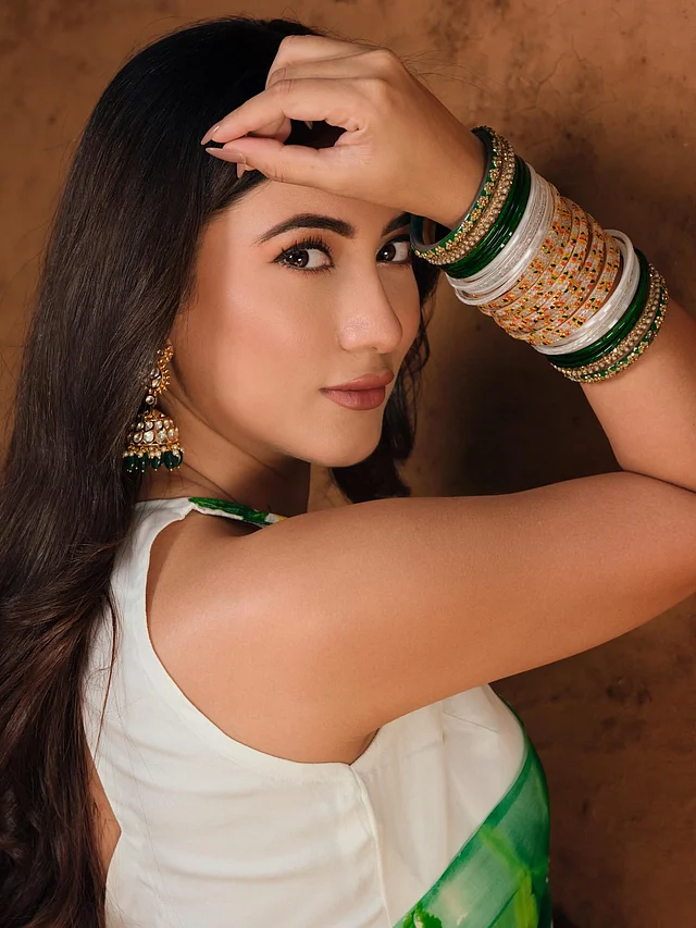 কানে পরেছেন গোল্ড ফিনিশের সঙ্গে কুন্দন-স্টাইলের পাথরের কাজ করা ঝুমকা। এর সৌন্দর্য আরও বাড়িয়েছে ঝুলন্ত সবুজ বিডস