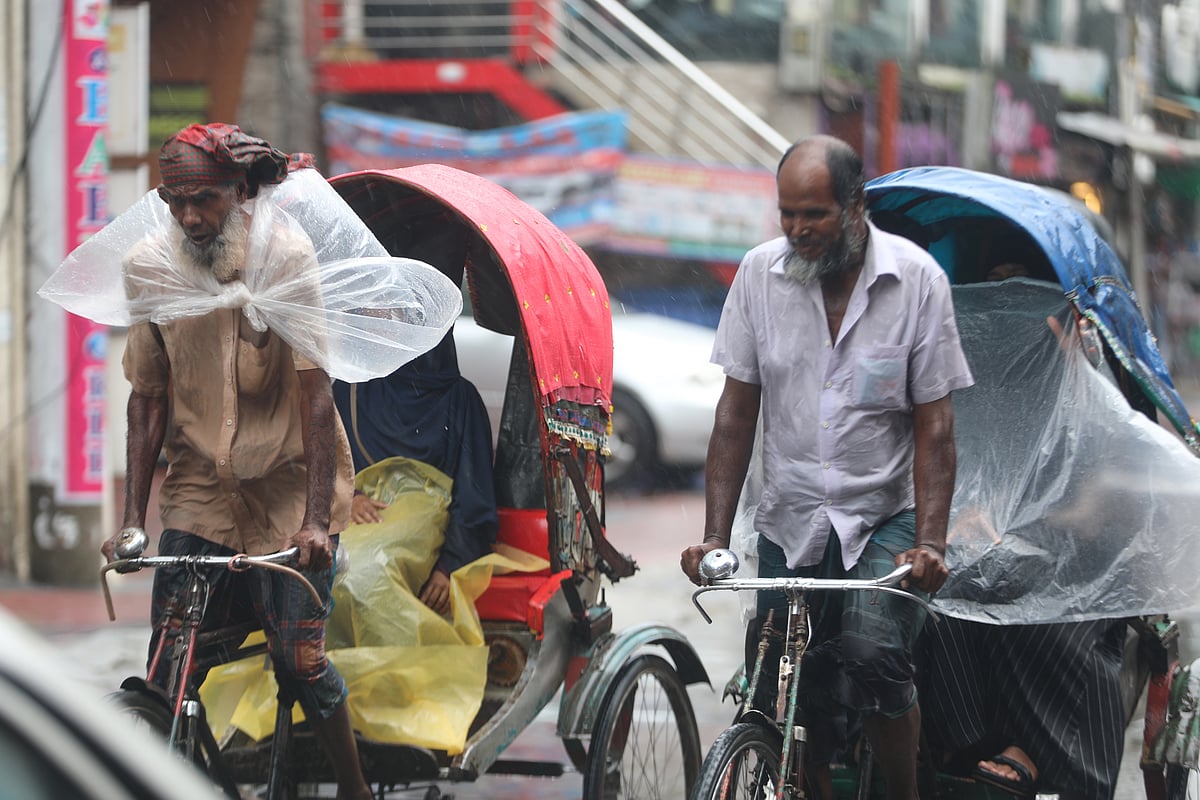 বৃষ্টিতে ভিজে রিকশা চালাচ্ছেন চালকেরা