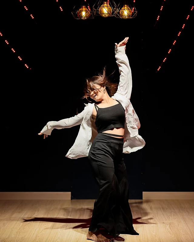 কালো ব্রালেট, ম্যাচিং প্যান্ট আর সাদা শার্টে পারফর্ম করছেন তিনি 