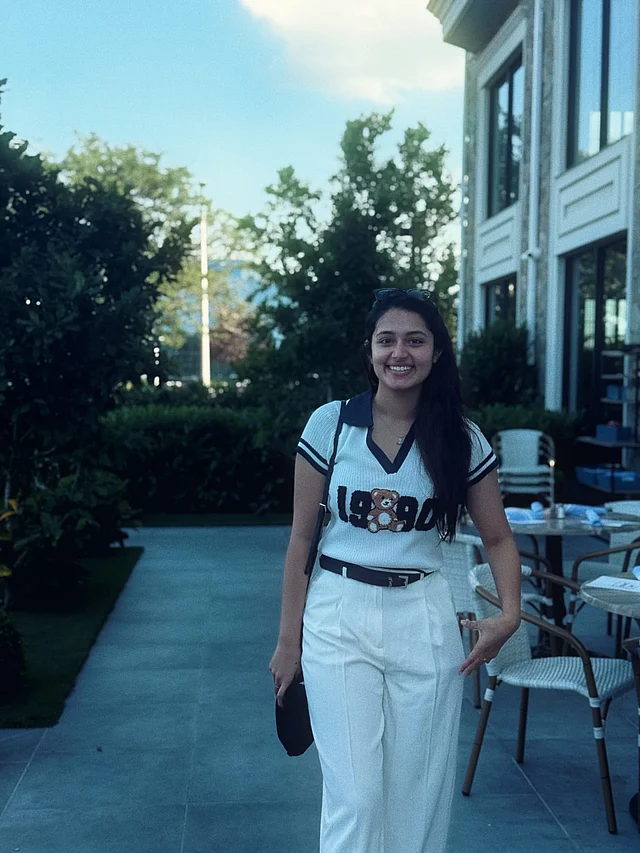 বেল্ট দিয়ে এর সঙ্গে হাই ওয়েস্টেড সাদা প্যান্ট পরেছেন তিনি। সঙ্গে আছে কালো ব্যাগ। 