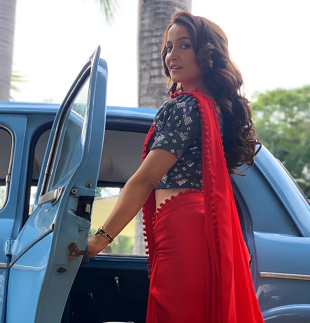 এখানে আবার একই রঙের লেস বর্ডারের লাল শাড়ির সঙ্গে আছে কন্ট্রাস্ট পাফড স্লিভসের ব্লাউজ 