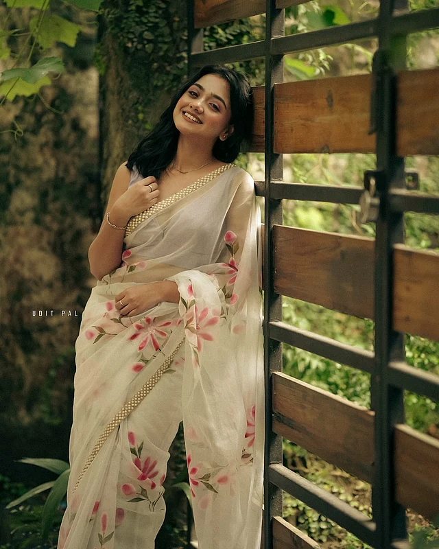 সাদা ফ্লোরাল শাড়িতে মুক্তাসজ্জিত বর্ডারের সৌন্দর্য, সঙ্গে স্লিভলেস ব্লাউজ। তাঁর উপস্থিতিতে যেন ছড়িয়ে পড়েছে শুভ্রতার কোমল আবেদন।