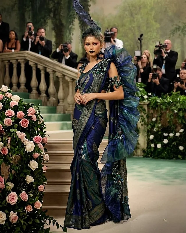 কিছুটা পিকক কালার প্যালেটে ডিজাইন করা শাড়ির সঙ্গে নজর কাড়ছে আঁচলের জায়গায় গ্যাদার্ড ফেব্রিকের এক্সটেনশন 