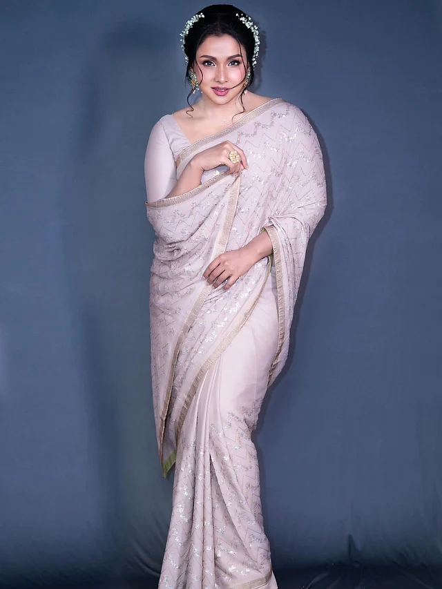 ফ্লোউই ফেব্রিকের শাড়িতে আছে একই কালার প্যালেটের স্টোন ও স্বচ্ছ চুমকির কাজ। সঙ্গে আছে সরু স্টোনের বর্ডার 