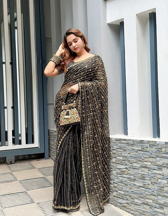 কালো জর্জেট শাড়ির পুরোটা জুড়ে সোনালির ডুরে প্যাটার্নের কারুকাজ। সঙ্গে ম্যাচিং বটুয়া 