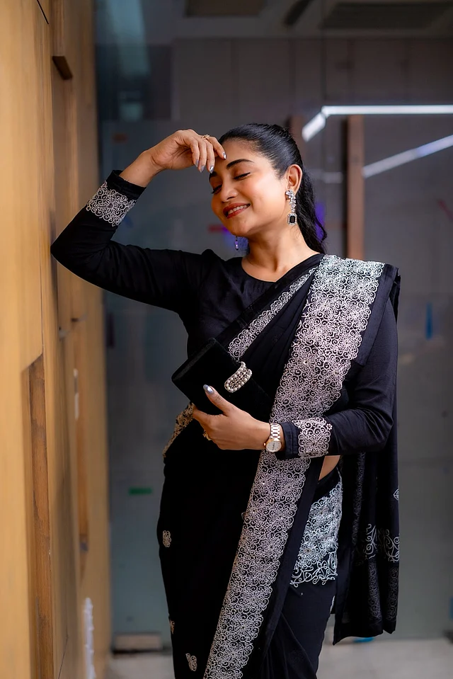 সাদা এমব্রয়ডারি করা চওড়া পাড়ের কালো শাড়ি পরেছেন অথই 