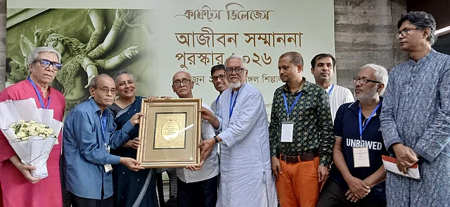 প্রতিমাশিল্প হরিপদ পালের (মাঝে) হাতে সম্মননা স্মারক তুলে দিচ্ছেন অতিথিরা