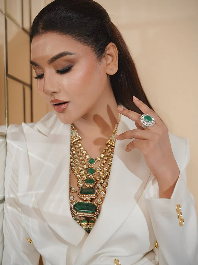 এর সঙ্গে হাতে পরেছেন একই সবুজ পাথর বসানো বড় স্টেটমেন্ট রিং, যা নেকলেসের সঙ্গে সুন্দরভাবে মিলে গেছে