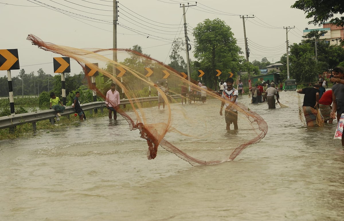 মহাসড়কে ওঠা পানিতে জাল ফেলে মাছ ধরছেন লোকজন