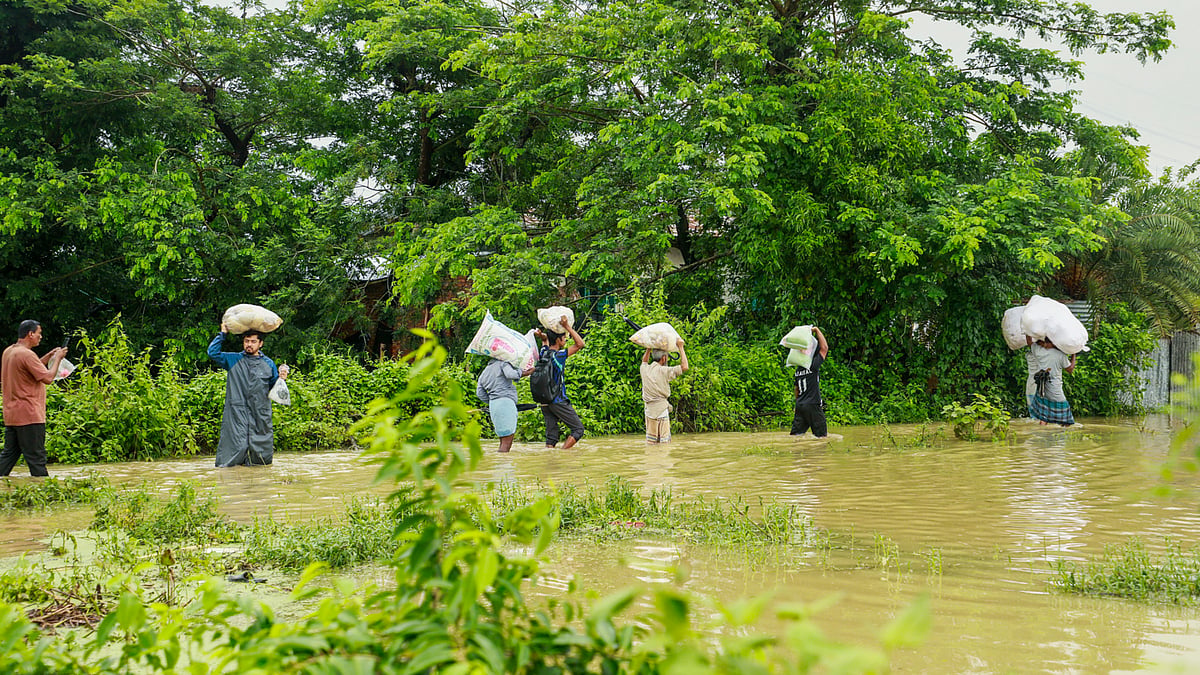 ত্রাণ নিয়ে ফিরছেন কয়েকজন বন্যাকবলিত মানুষ 