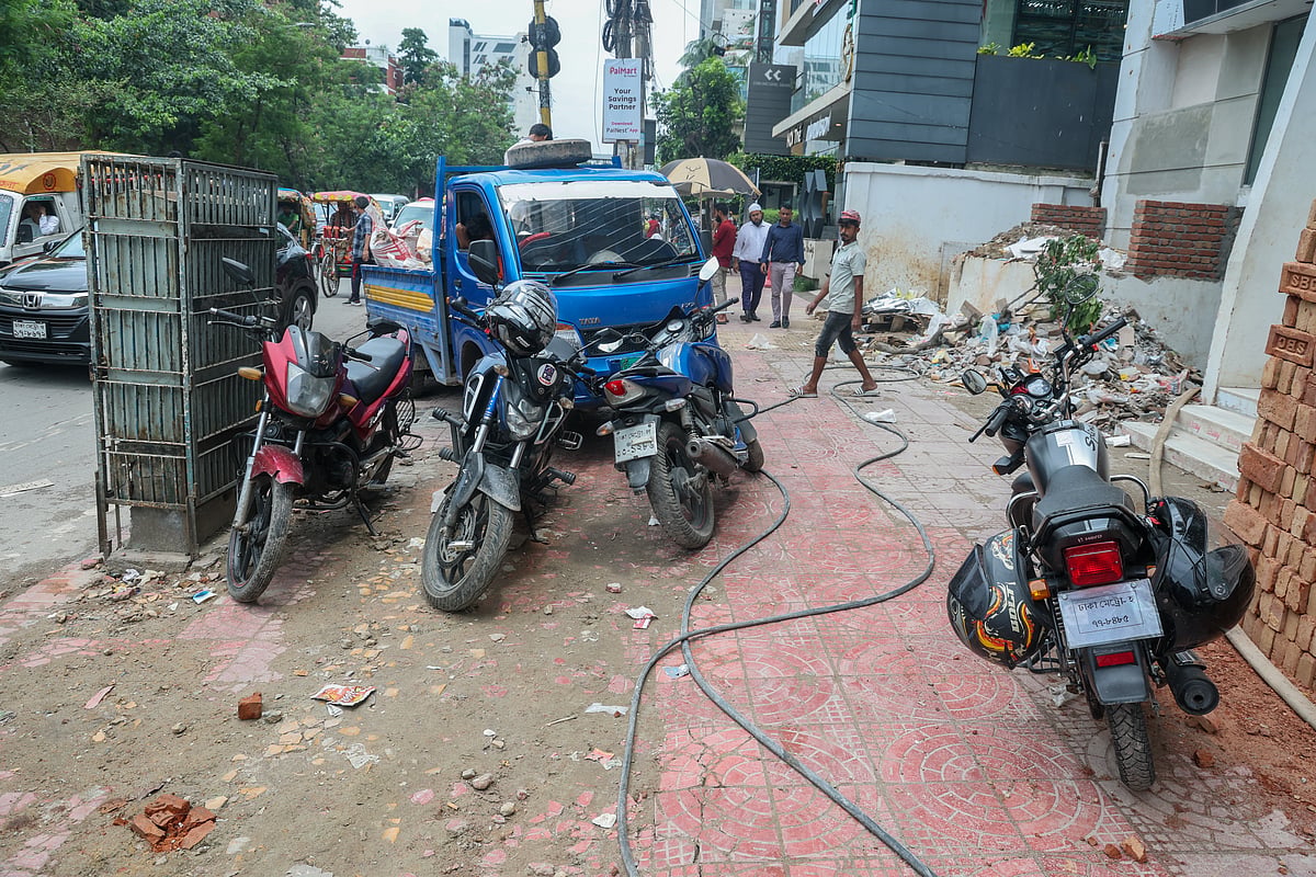 ফুটপাতে মোটরসাইকেল ও পিকআপ ভ্যান রেখে পথচারীদের চলাচলে বাধা সৃষ্টি করা হয়েছে। গতকাল রোববার রাজধানীর ধানমন্ডির শংকরে।