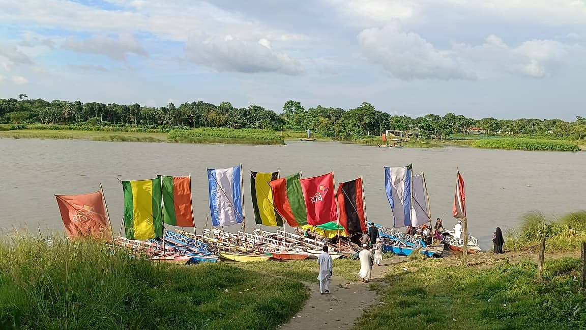 বর্ষার পানিতে টইটম্বুর নদে বাহারি পাল তুলে যাত্রীর অপেক্ষায় সারিবদ্ধ নৌকা 