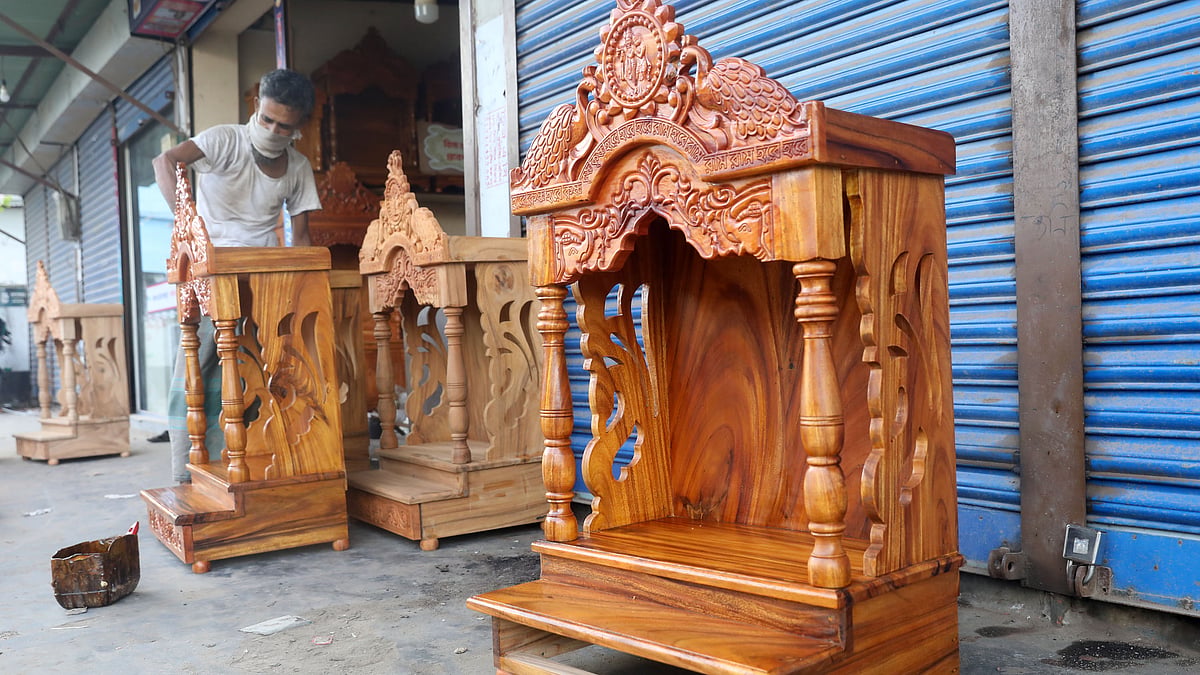 দোকানের সামনের বারান্দায় রাখা সিংহাসনে চলছে রঙের কাজ। একেকটি সিংহাসনের উচ্চতা দেড় ফুট থেকে মোটামুটি পাঁচ ফুট পর্যন্ত হয়