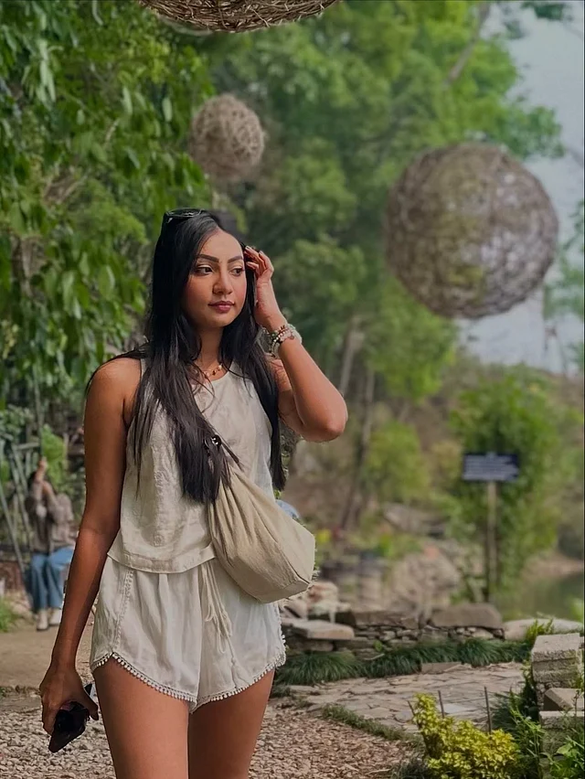 অফ হোয়াইট শর্ট আর স্লিভলেস টপে সবুজের মাঝে হাঁটছেন তিনি 
