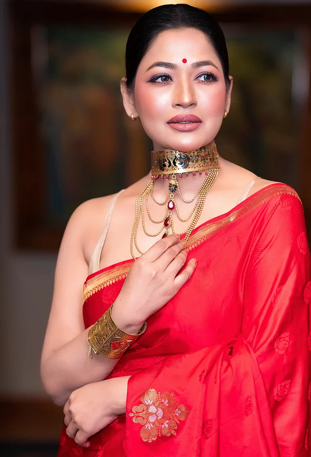 স্টেটমেন্ট গয়না আর স্লিভলেস ব্লাউজের সঙ্গে সিম্পল লাল শাড়িতে বোল্ড ও আত্মবিশ্বাসী বাঁধন  