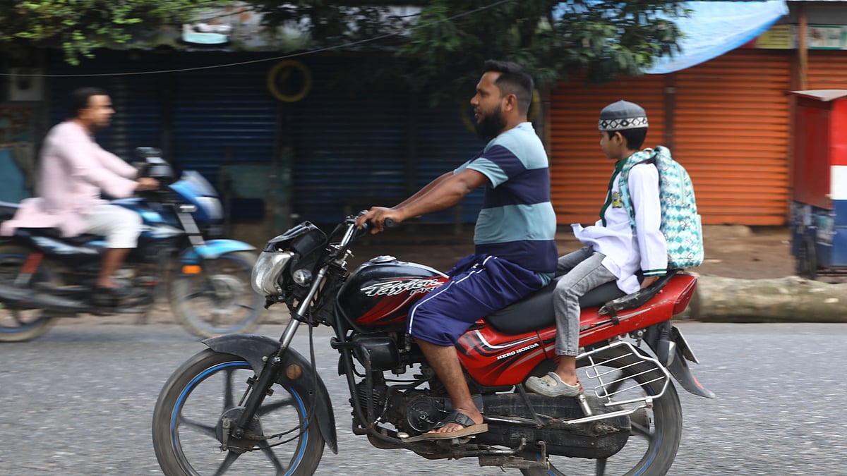 দুই দিকে দুই মোটরসাইকেল, চালক কিংবা পেছনের খুদে আরোহী—কারও মাথাতেই হেলমেট নেই।