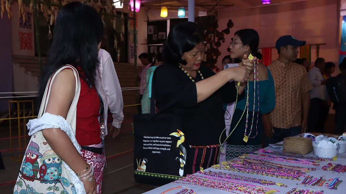 প্রদর্শনীতে পুঁতির তৈরি গয়না দেখছেন মারমা সম্প্রদায়ের এক নারী