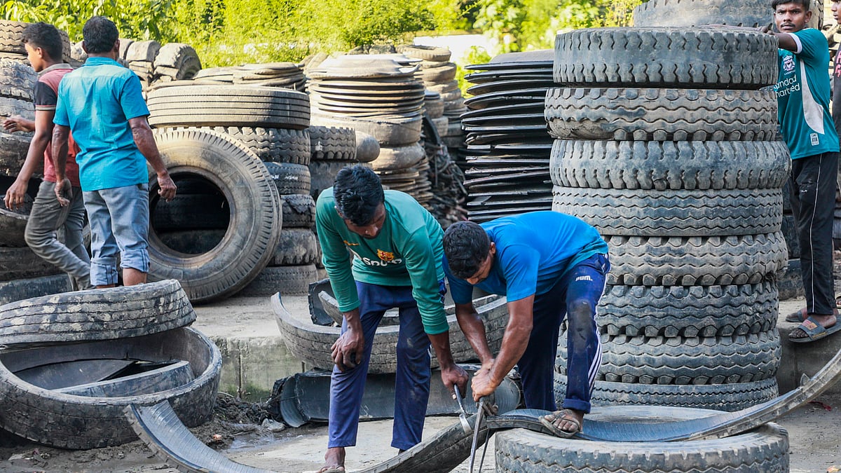 ভারী টায়ার কাটা সহজ কাজ নয়। ধারালো হ্যাকস ব্লেড দিয়ে টায়ারের বড় একটি অংশ কেটে আলাদা করছেন দুই শ্রমিক