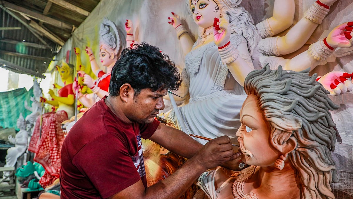 প্রতিমায় তুলির আঁচড়ে মনোনিবেশ এক শিল্পীর