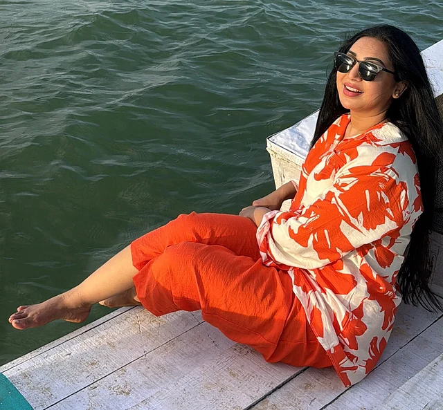 পানির ধারে খালি পায়ে প্রভা। কমলা প্রিন্টের সাদা শার্ট আর কমলা প্যান্ট পরেছেন তিনি 