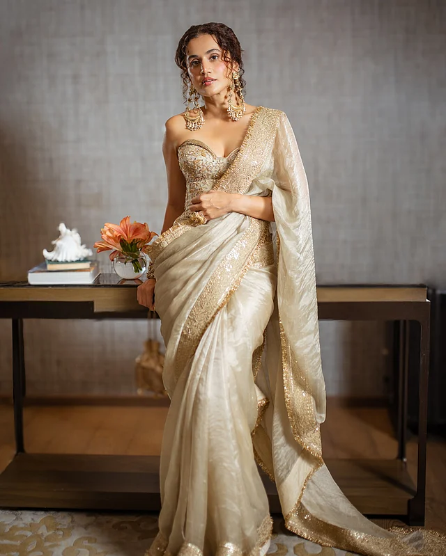  প্রচলিত ব্লাউজের বদলে কাঠামোবদ্ধ করসেট বেছে নেওয়ায় শাড়ির ফ্লুইড ড্রেপ পেয়েছে আরও শার্প লাইন। ফলে তাপসীর পুরো সিলুয়েট দেখাচ্ছে একসঙ্গে কোমল ও আত্মবিশ্বাসী।