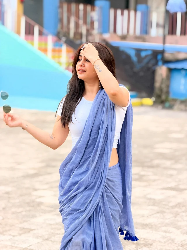 নীল হ্যান্ডলুম সুতি শাড়ির সঙ্গে সাদা রিবড টপ পরেছেন অভিনেত্রী জেসমিন রায়। খোলা চুল আর চোখে কাজলের সাজে স্নিগ্ধ উৎসবের লুকটিকে আকর্ষণীয় করে তুলেছেন তিনি।