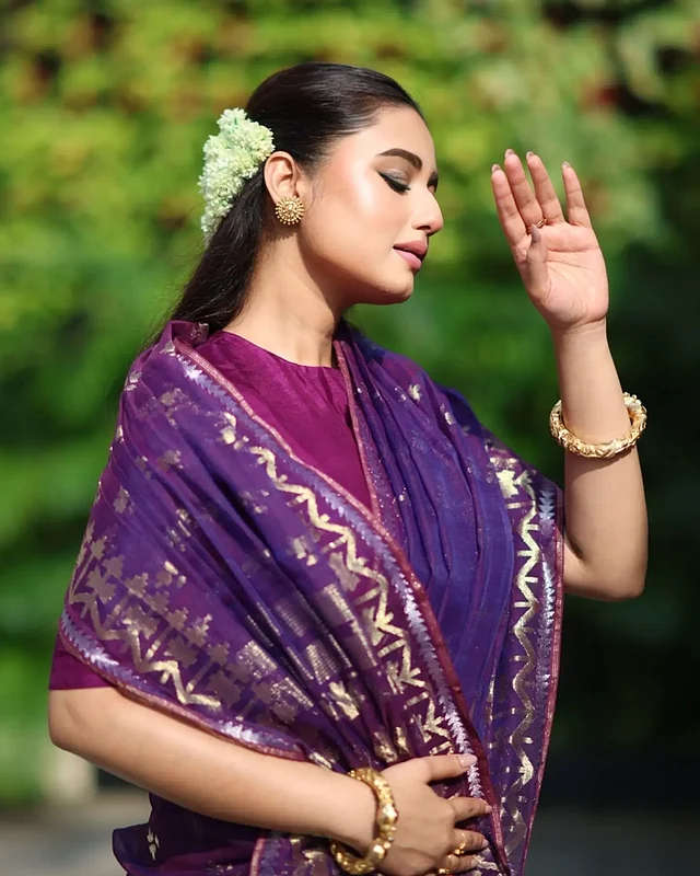 লুক সম্পূর্ণ করতে বেছে নিয়েছেন হাতের চওড়া বালা, কানের সোনালি টপ ও চুলে সাদা ফুলের গজরা; আর সেজেছেন ন্যুড মেকআপে।