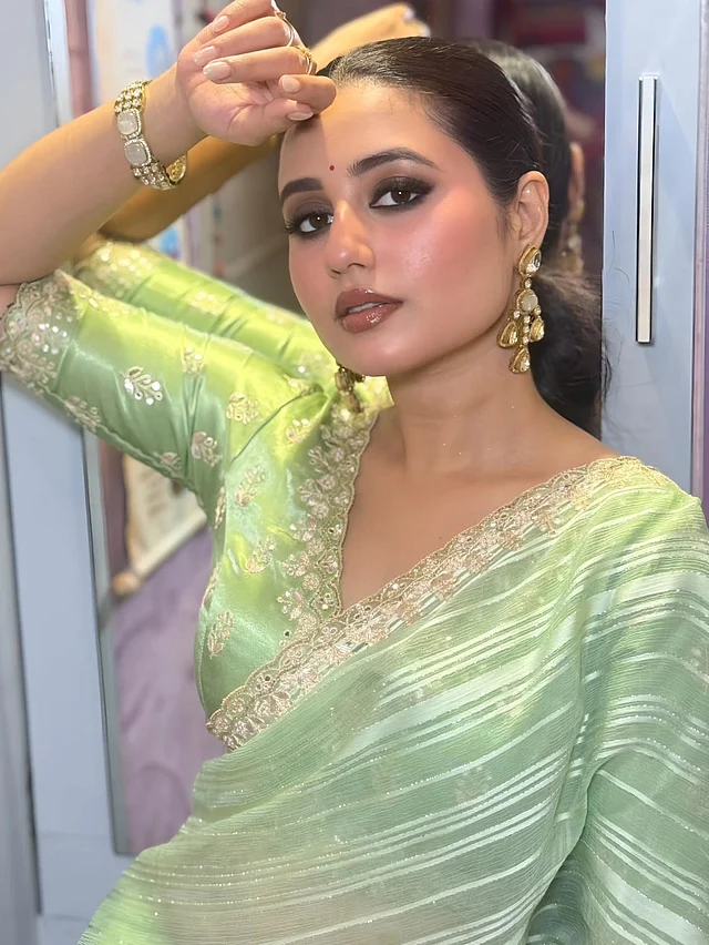পেস্তা সবুজ  শিফন স্ট্রাইপড শাড়িতে স্বস্তিকা দত্ত। সঙ্গে অল-ওভার এমব্রয়ডারি করা ম্যাচিং ব্লাউজ পরেছেন। আর সাজে রয়েছে কপালের ছোট্ট লাল টিপ, কানে বড় পাথরের দুল, ড্রামাটিক স্মোকি আই এবং টাইট স্লিক পনিটেল হেয়ারস্টাইল।
