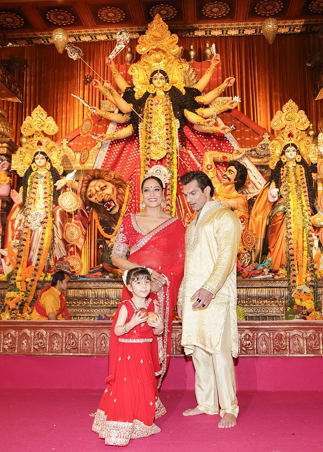 দুর্গাপ্রতিমার সামনে গর্জিয়াস লাল শাড়ির লুকে বিপাশা বসু, সোনালি কুর্তা-পায়জামায় করণ সিং গ্রোভার এবং মায়ের সঙ্গে মিলিয়ে সোনালি পাড়ের লাল লেহেঙ্গায়  ধরা দিয়েছে তাঁদের মেয়ে দেবী।