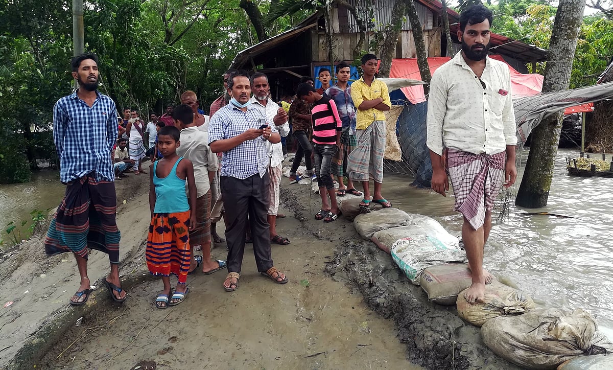 বাঁধ উপচে পানি ঢুকছে লোকালয়ে। স্থানীয় ব্যক্তিরা তা সংস্কার করছেন। গত বুধবার বিকেলে ভোলা সদর উপজেলার ধনিয়া কোড়ারহাট এলাকায়।
