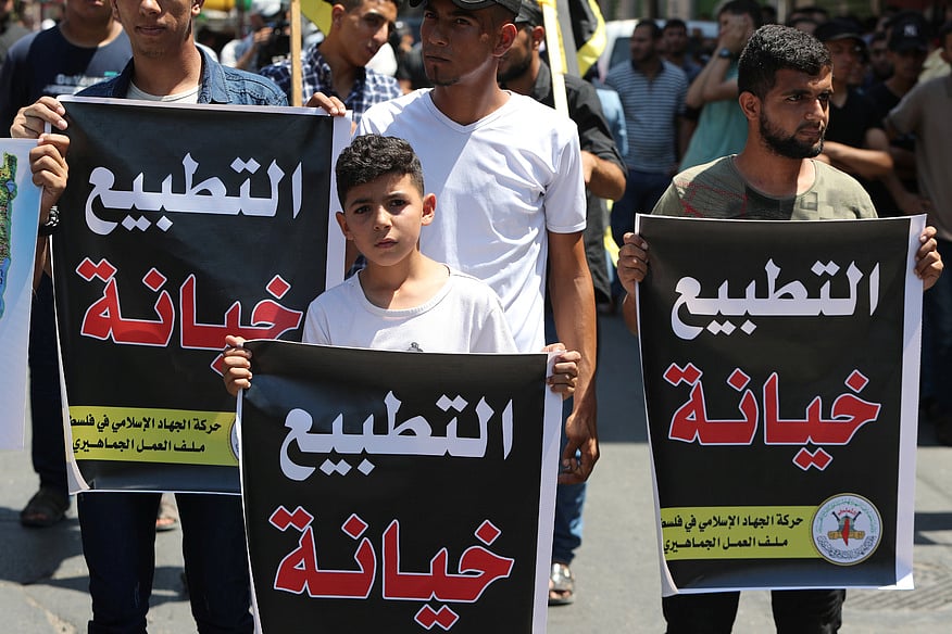 সংযুক্ত আরব আমিরাতের সঙ্গে ইসরায়েলের চুক্তির প্রতিবাদে ফিলিস্তিনে বিক্ষোভ। এ সময় বিক্ষোভকারীদের হাতে থাকা ব্যানারে আরবিতে লেখা ছিল ‘স্বাভাবিকীকরণের নামে বিশ্বাসঘাতকতা’। গাজা উপত্যকায় গত শুক্রবার।