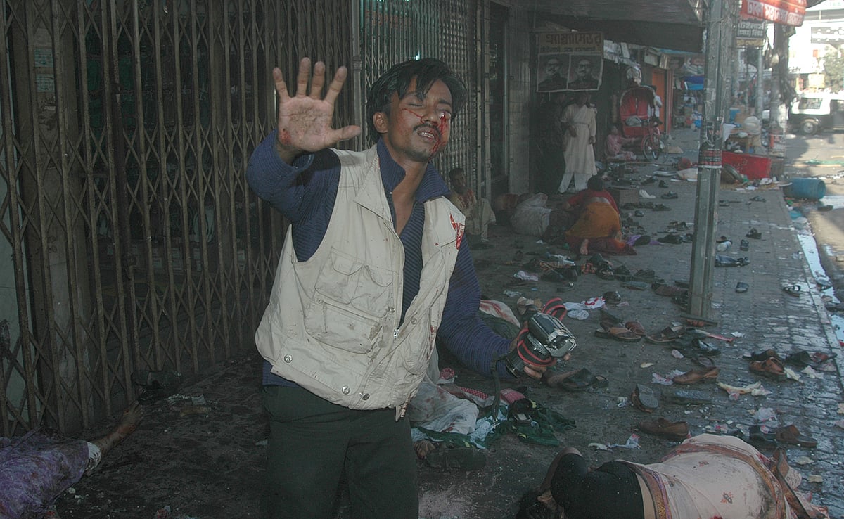 গ্রেনেড হামলার দিনে আওয়ামী লীগের সমাবেশে পেশাগত দায়িত্ব পালনের সময় আহত ফটোসাংবাদিক বাপ্পির বাঁচার জন্য আকুতি। পাশে ধ্বংসস্তূপে পরিণত হওয়া সমাবেশ। ২০০৪ সালে রাজধানীর বঙ্গবন্ধু অ্যাভিনিউয়ে দলীয় কার্যালয়ের সামনে