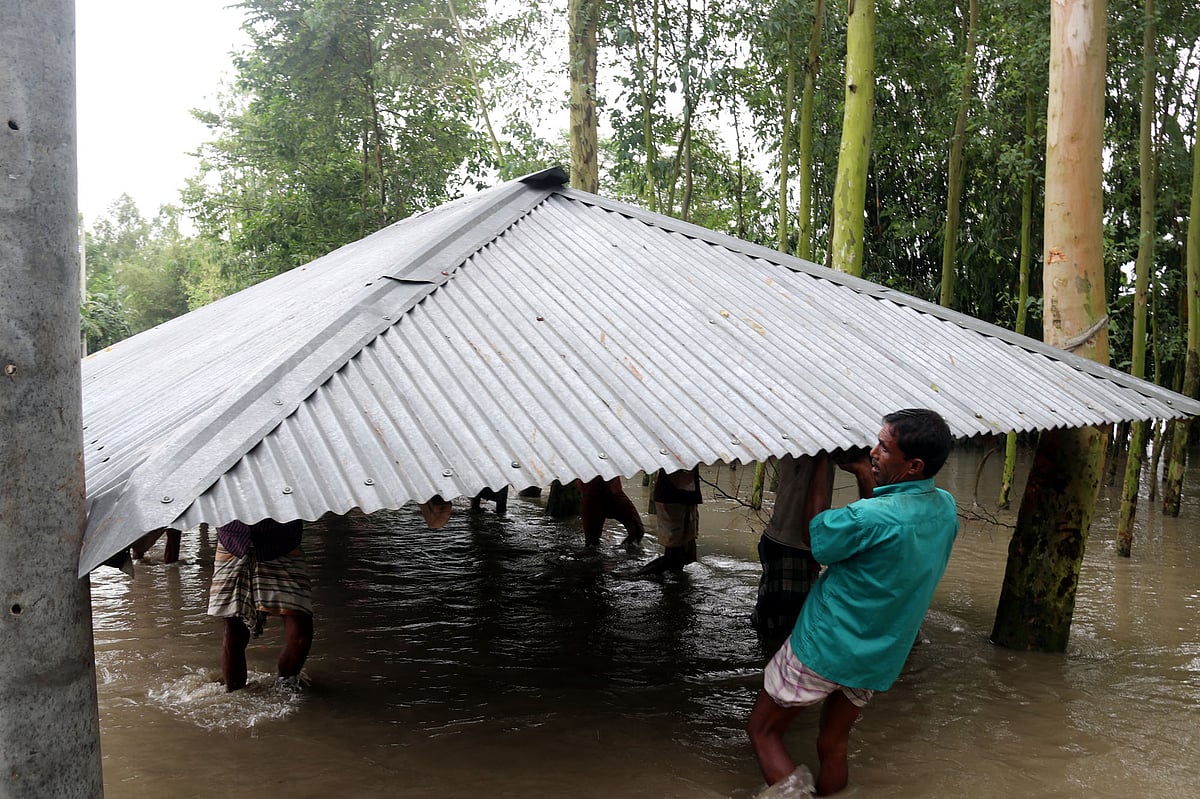 পানির তোড়ে ভেঙে যাচ্ছে ঘরবাড়ি। দ্রুত ঘরবাড়ি সরিয়ে নিয়ে যাচ্ছেন খোরশেদ আলম। রংপুরের গঙ্গাচড়া উপজেলার লক্ষ্মীটারি ইউনিয়নের পুর্ব ইচলি এলাকা