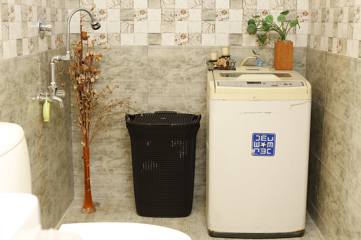 স্নানঘরে জায়গা যদি বেশি থাকে তবে সেখানেই রাখা যায় ওয়াশিং মেশিন। এর চারপাশটা থাকুক গোছানো। ছবি: নকশা