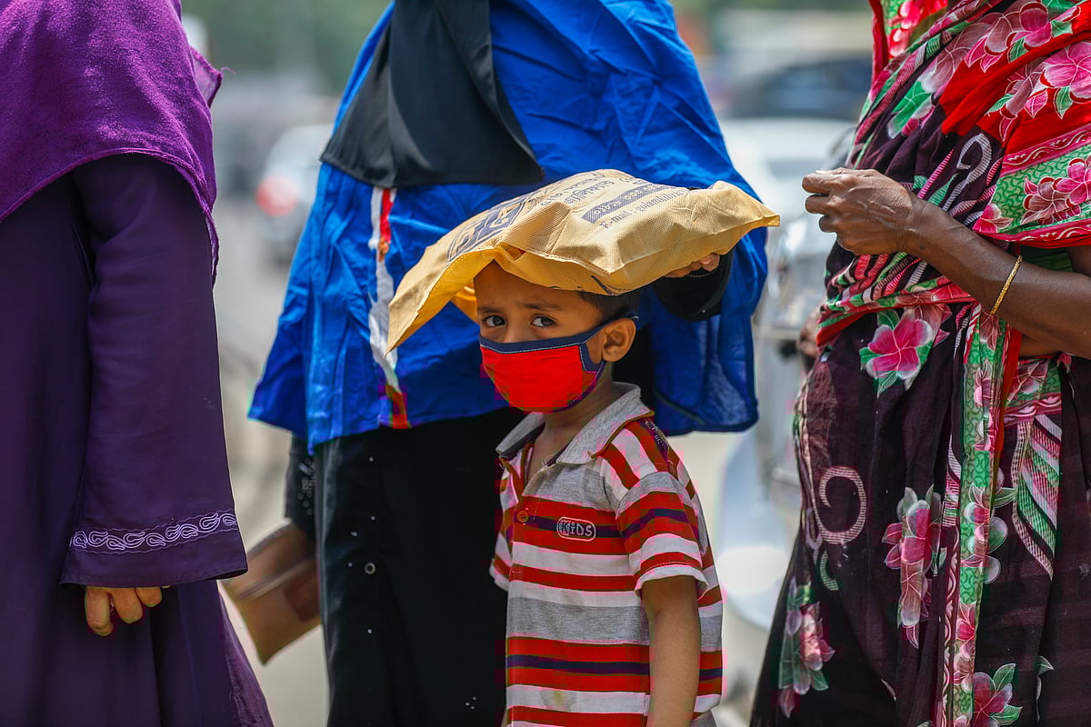 একদিকে দ্রব্যমূল্যের ঊর্ধ্বগতি, অন্যদিকে সামনে রমজান মাস। কদিন পরেই আবার দেশজুড়ে শুরু হচ্ছে লকডাউন। খোলাবাজার থেকে কম মূল্যে পণ্য কিনতে টিসিবির ট্রাকের সামনে ভিড়। বড়দের সঙ্গে দাঁড়িয়েছে ছোট্ট শিশুটিও। ফার্মগেট, ঢাকা, ১১ এপ্রিল