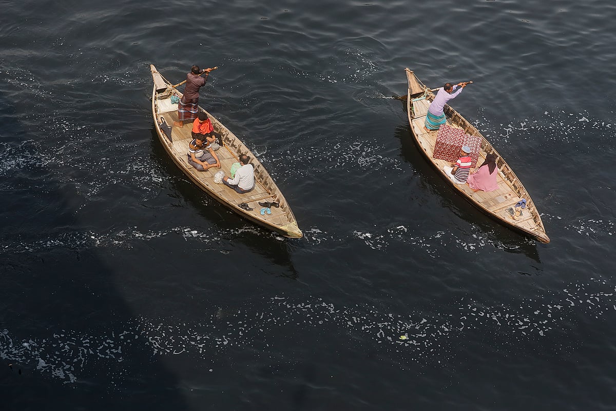 দূষণে বুড়িগঙ্গা নদীর পানির রং কালো হয়ে গেছে। দুর্গন্ধ ছড়াচ্ছে চারপাশে। এর মধ্য দিয়ে চলছে নৌকা। বাবুবাজার, ঢাকা, ২৬ এপ্রিল
