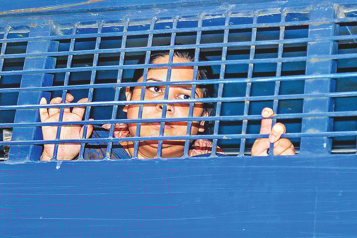 প্রিজন ভ্যানের গ্রিলের ফাঁকে সাংবাদিক রোজিনা ইসলামের চোখেমুখে মুক্তির প্রতিজ্ঞা। শুনানি শেষে রিমান্ড আবেদন নামঞ্জুর হওয়ার পর ঢাকার সিএমএম আদালতের সামনে