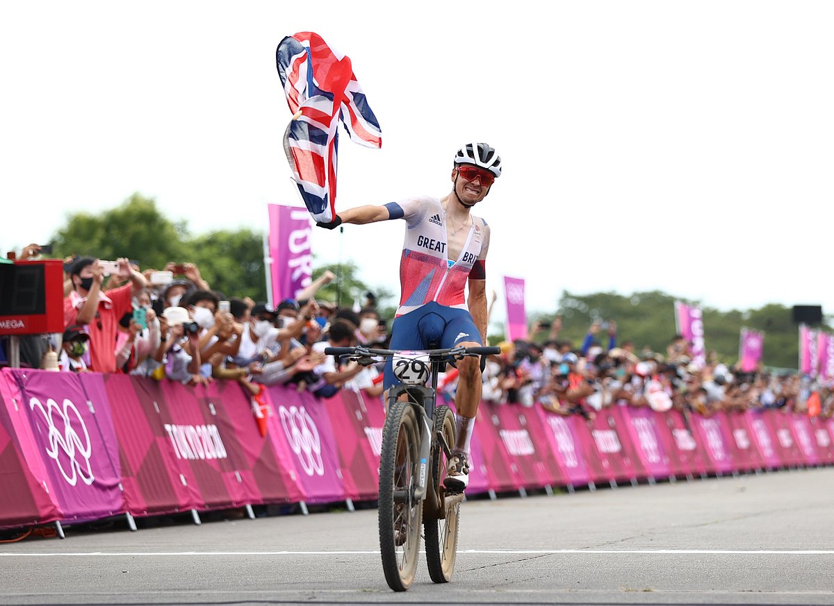 টোকিও অলিম্পিকে ছেলেদের মাউন্টেন বাইক ক্রস কান্ট্রি রেস জয়ের পর দেশের পতাকা হাতে টম পিডকক