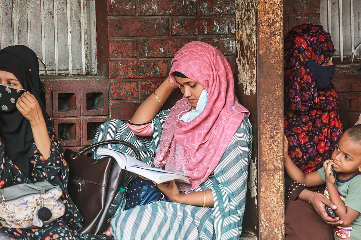 চাকরির পরীক্ষার আগে কেন্দ্রের বাইরে পড়াশোনা করছেন এক প্রার্থী