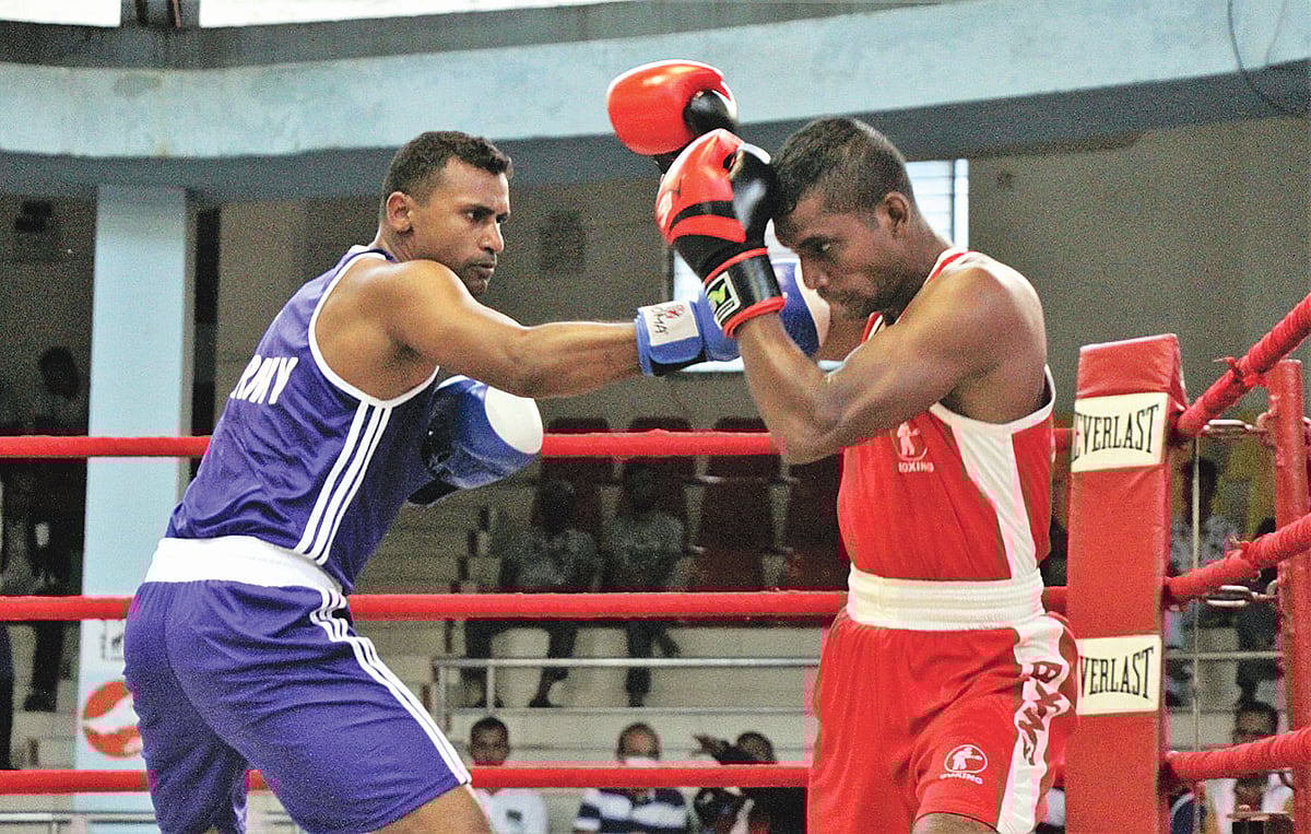 সেনাবাহিনীর  বক্সার মুজাহিদ হকের (নীল জার্সি) পাঞ্চ ঠেকানোর চেষ্টা পুলিশের শাহাবুদ্দিনের। কাল পল্টন মোহাম্মদ আলী বক্সিং স্টেডিয়ামে