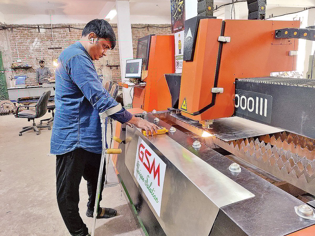 লাঠিতে ভর দিয়ে কোনোরকমে হাঁটতে পারেন সাইফুল আলম। তবে শক্তি, সাহস ও দৃঢ় প্রত্যয় নিয়ে কাজ করে চলেছেন তিনি