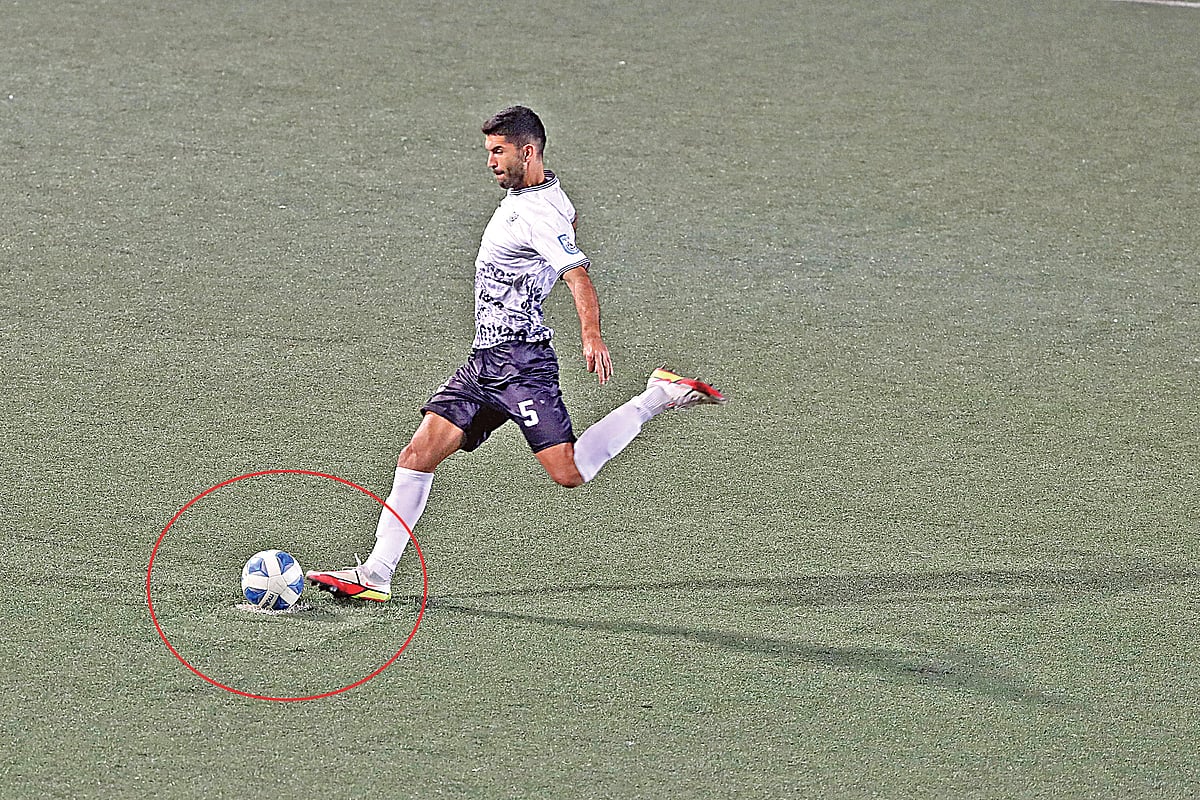 নষ্ট হয়ে গেছে টার্ফের কৃত্রিম ঘাস। কমলাপুর স্টেডিয়ামের এ রকম অনেক জোড়াতালি দেওয়া (ছবিতে লাল বৃত্তের অংশ) টার্ফেই চলছে ফেডারেশন কাপ ফুটবল। গতকাল স্বাধীনতা ক্রীড়া সংঘের বিপক্ষে ম্যাচে পেনাল্টি নিচ্ছেন মোহামেডানের অস্ট্রেলিয়ান ডিফেন্ডার অ্যারন রিয়ারডন