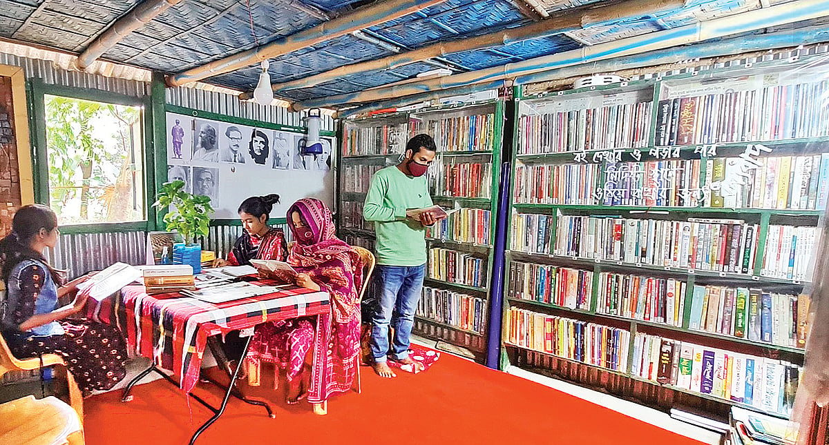 গাজীপুরের নীলের পাড়া গ্রামের সহকারী শিক্ষক মাধব চন্দ্র মণ্ডলের ‘বইপোকা’ পাঠাগারে বই পড়ায় ব্যস্ত পাঠকেরা
