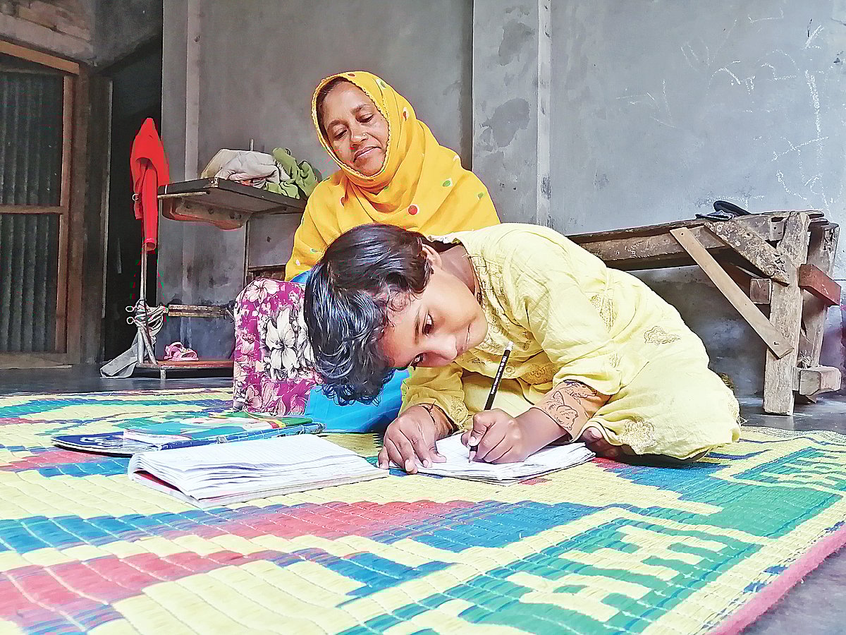 মায়ের সঙ্গে বসে লিখছে সুরাইয়া। ডান হাত কাজ করে না, তাই বাঁ হাতেই লেখার  অনুশীলন করছে সে। গতকাল মাগুরার দোয়ারপাড়ায়