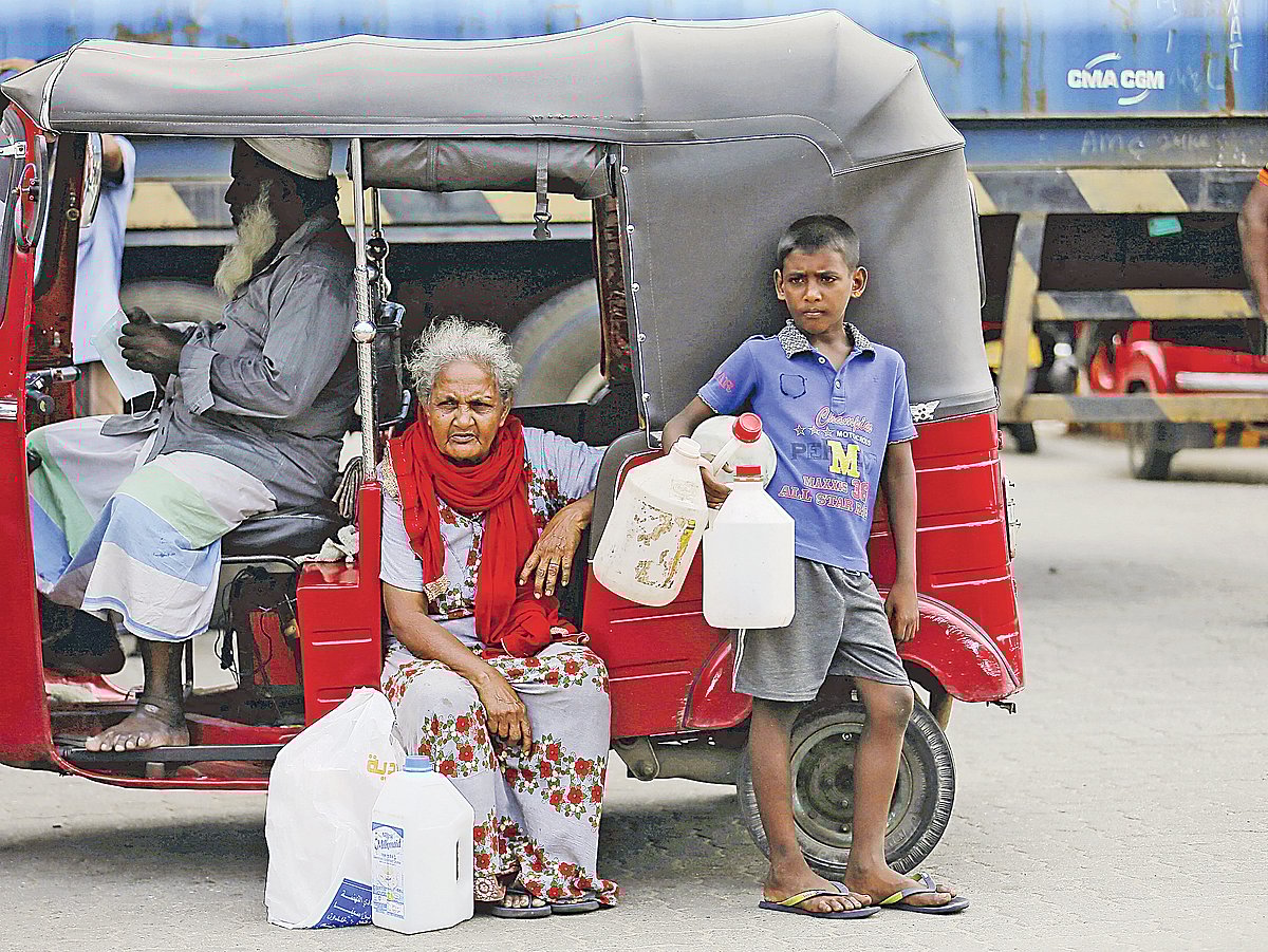 রান্নার কাজে ব্যবহৃত গ্যাস–সংকটের কারণে বিকল্প জ্বালানি কেরোসিন তেল পেতে পেট্রলপাম্পে অপেক্ষা করছে একটি পরিবার। গত সোমবার কলম্বোতে